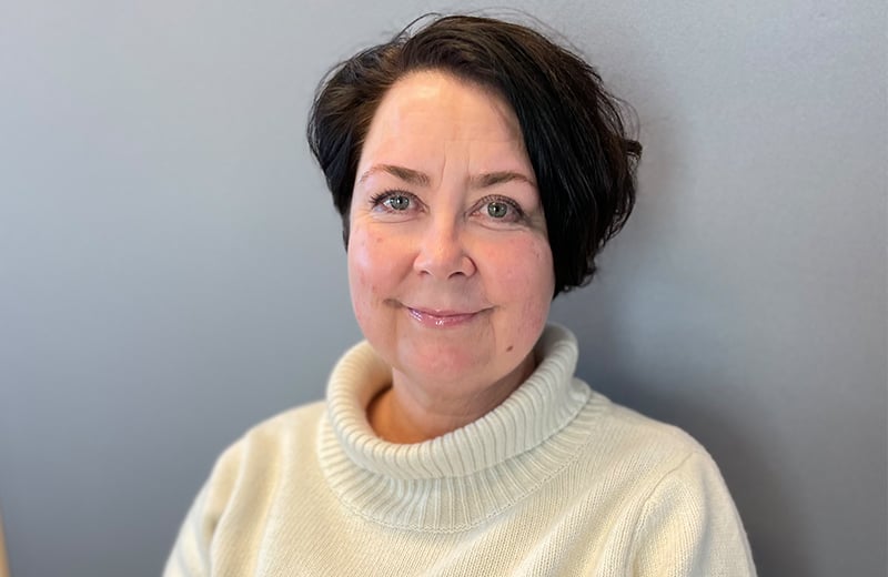 En kvinne som smiler til kameraet