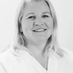 En kvinne som smiler til kameraet