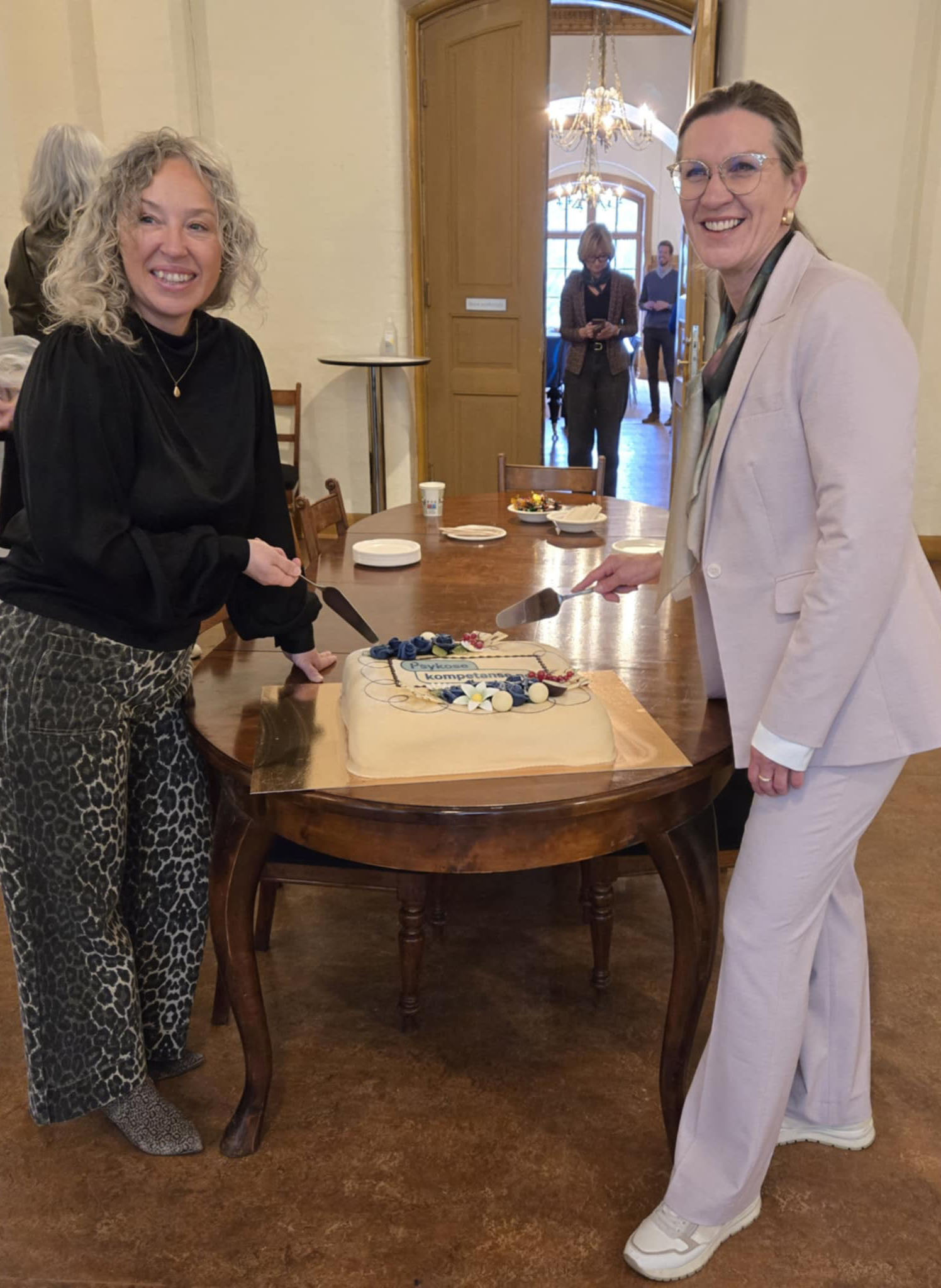 Et par kvinner som skjærer en kake