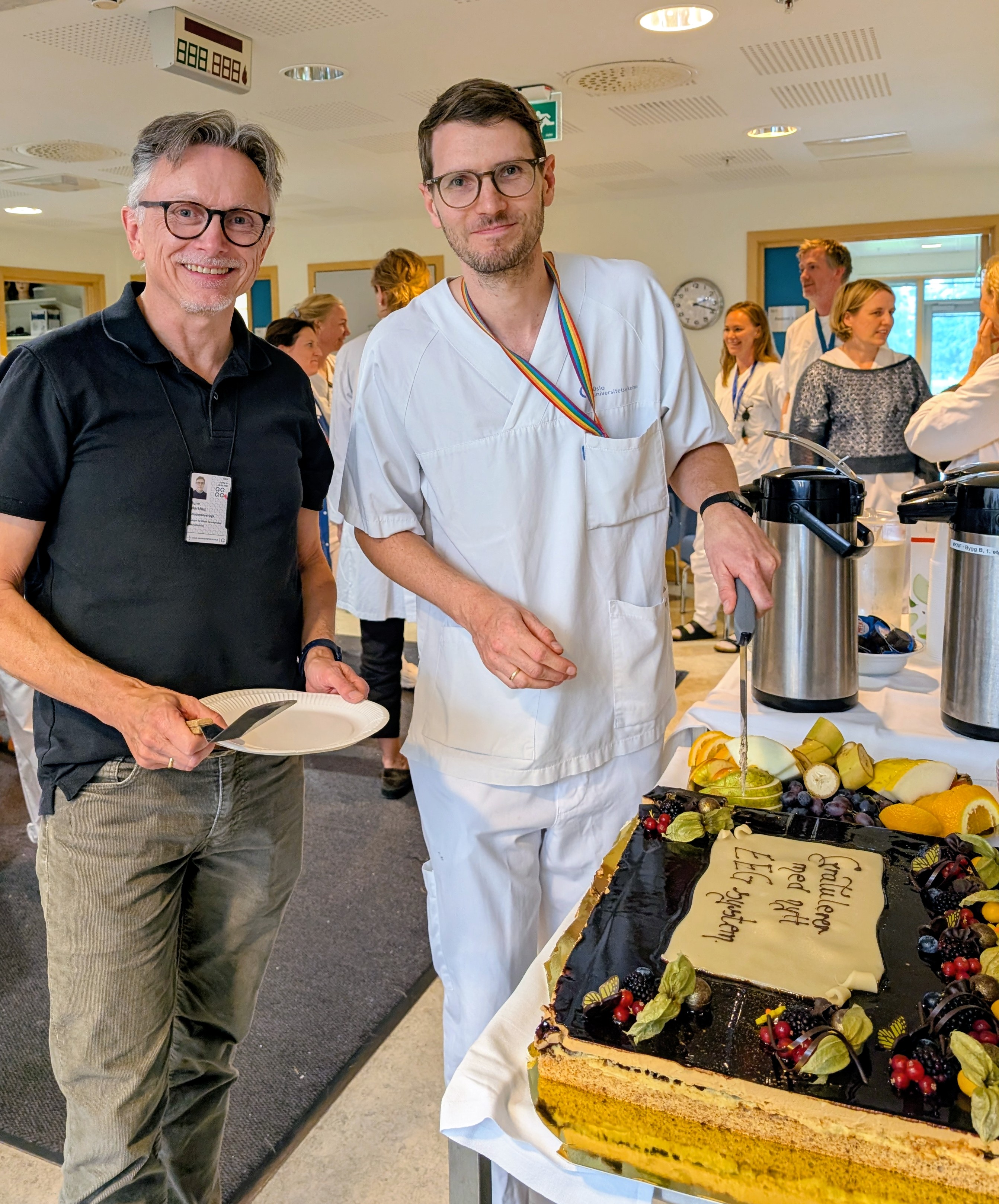 En mann som holder en tallerken med mat ved siden av en mann som holder en tallerken