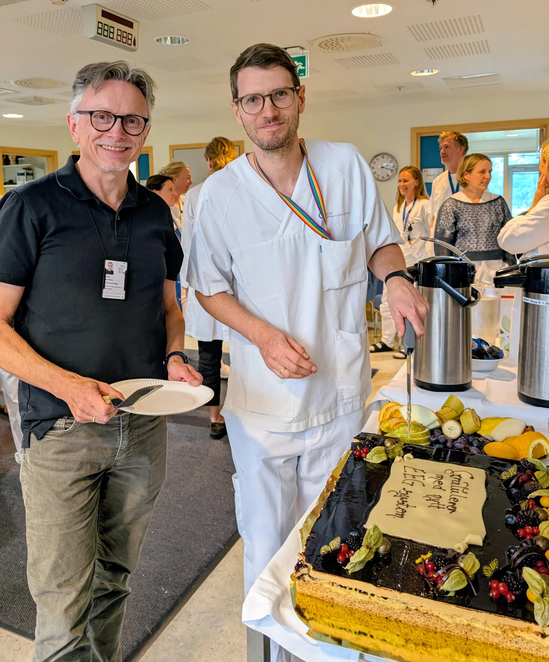 En mann som holder en tallerken med mat ved siden av en mann som holder en tallerken