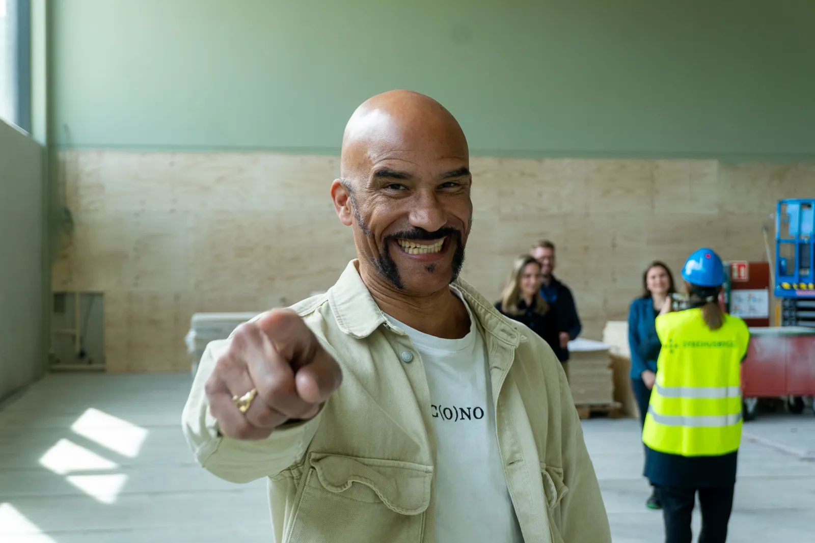 En mann som smiler med hånden på haken