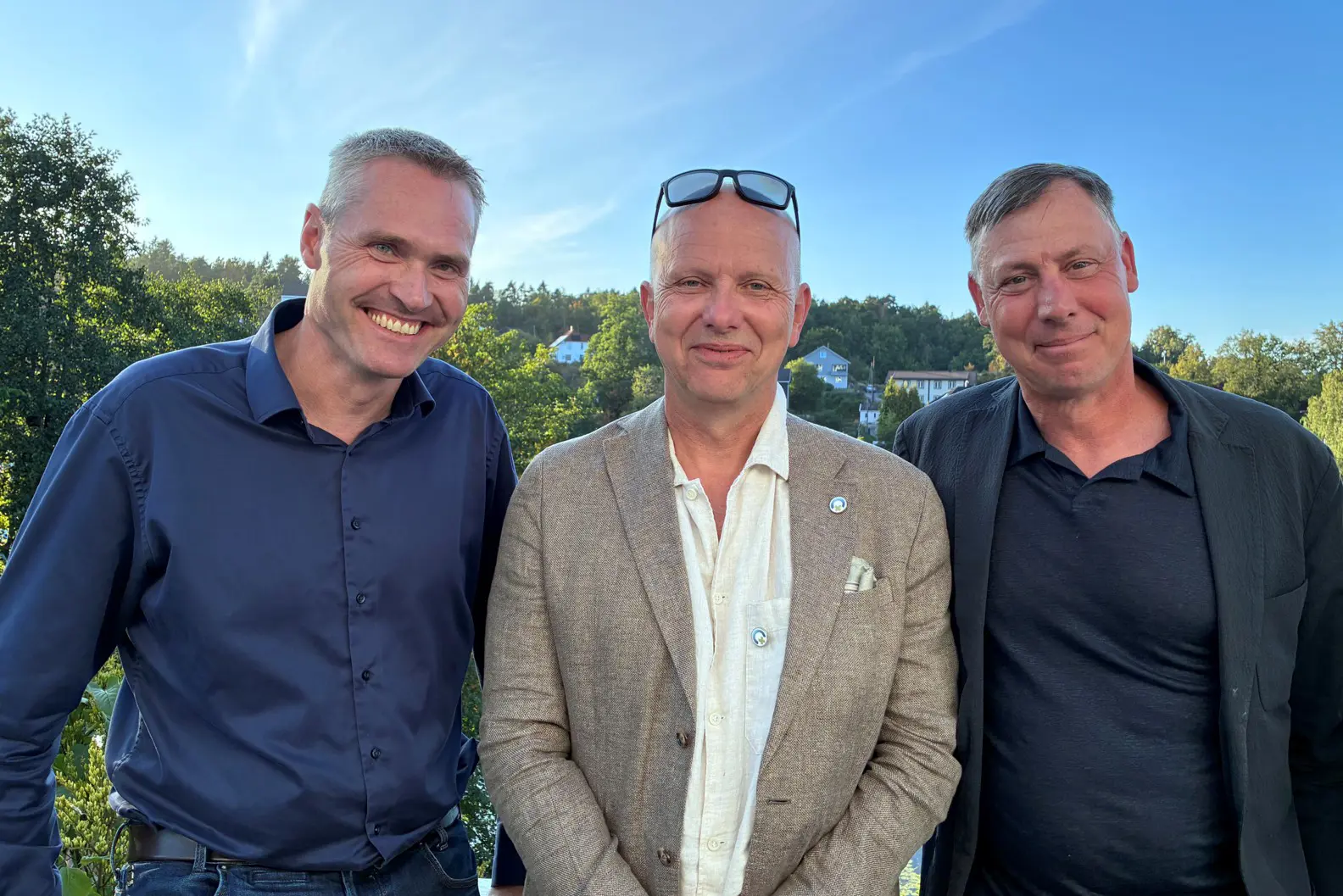 En gruppe menn som smiler
