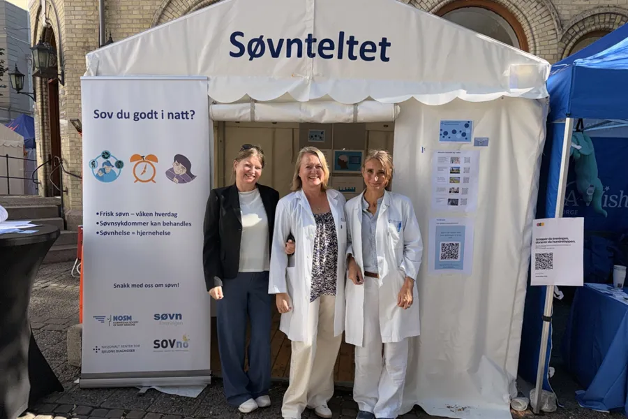 En gruppe mennesker som står foran et telt