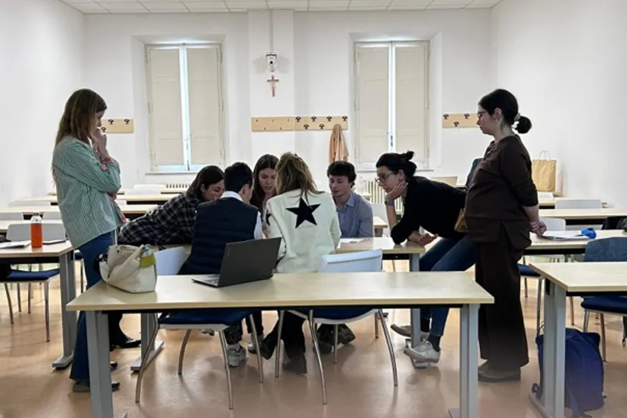 En gruppe mennesker som sitter ved et bord med bærbare datamaskiner