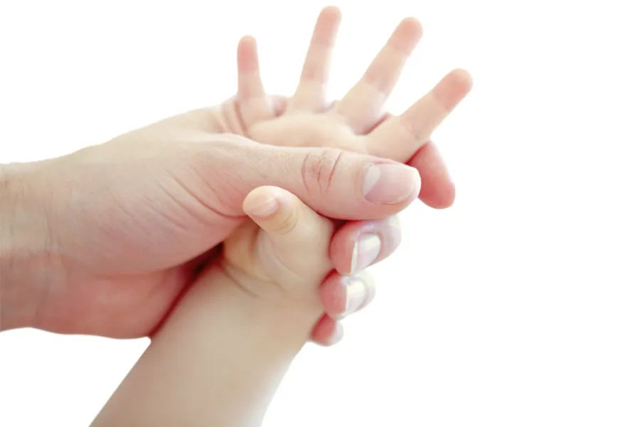 En voksen hånd som holder en barnehånd