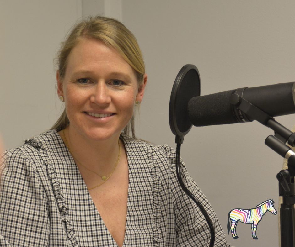 En kvinne som smiler ved siden av en mikrofon