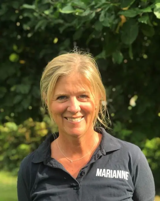 En kvinne som smiler foran et tre