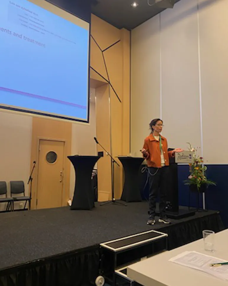 En dame står foran et projektorlerret