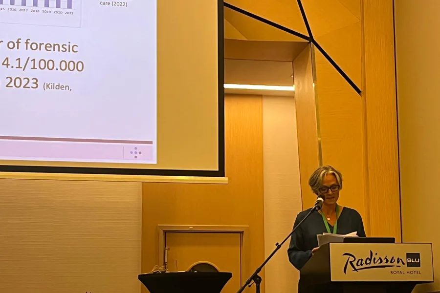 En dame står foran et projektorlerret