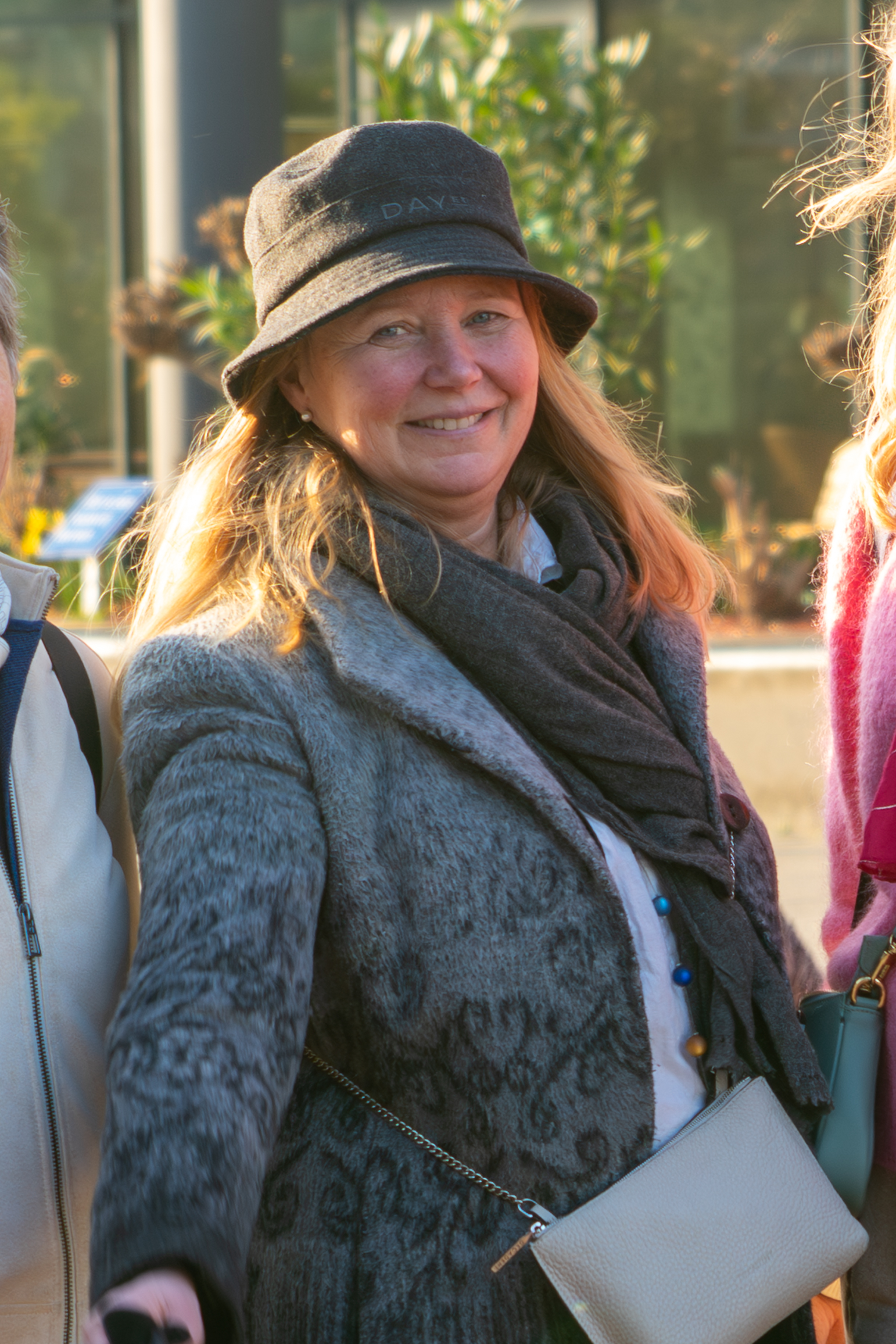 Nina i Kreftforeningen står ute med en hatt på hodet og smiler til fotografen.