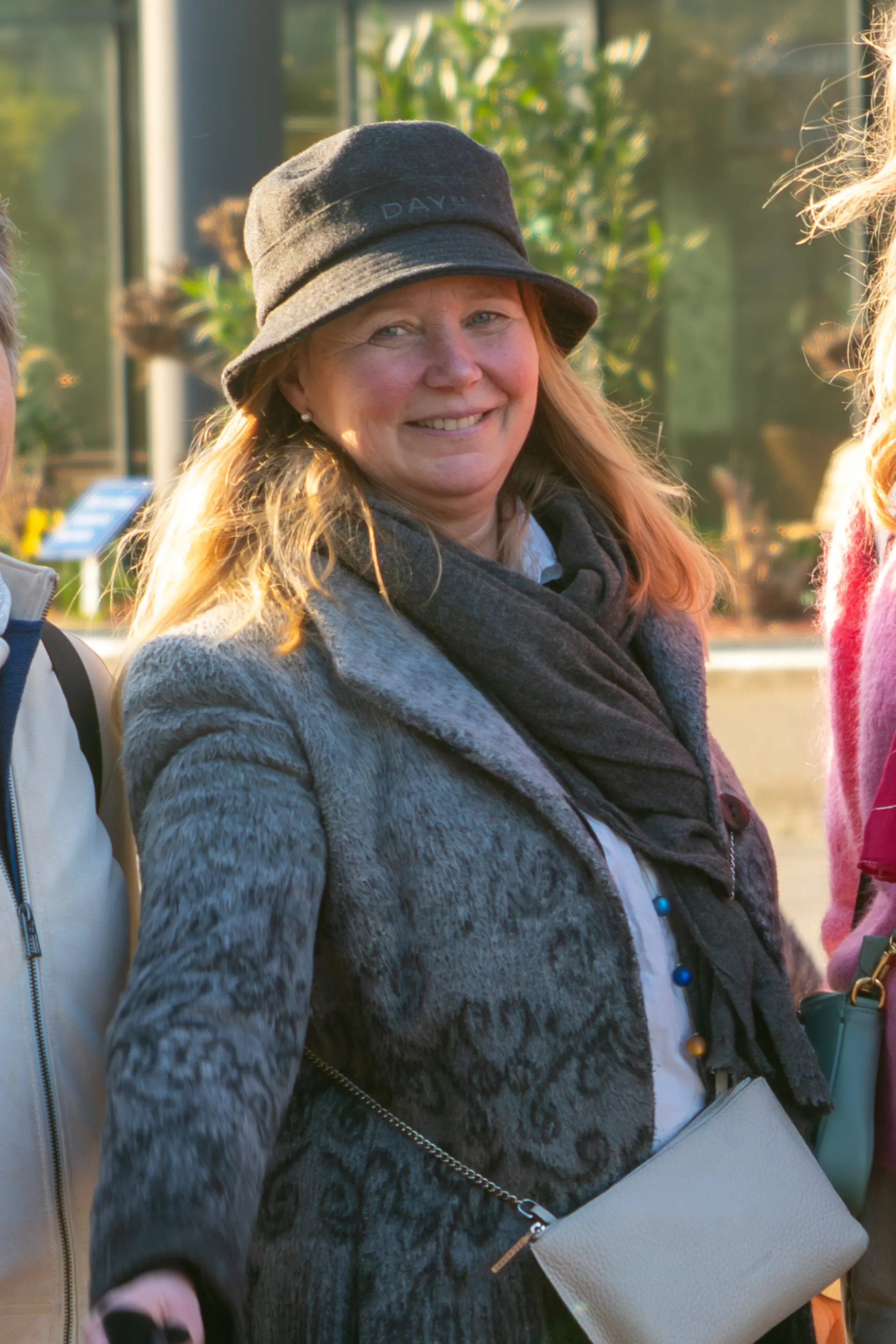 Nina i Kreftforeningen står ute med en hatt på hodet og smiler til fotografen.
