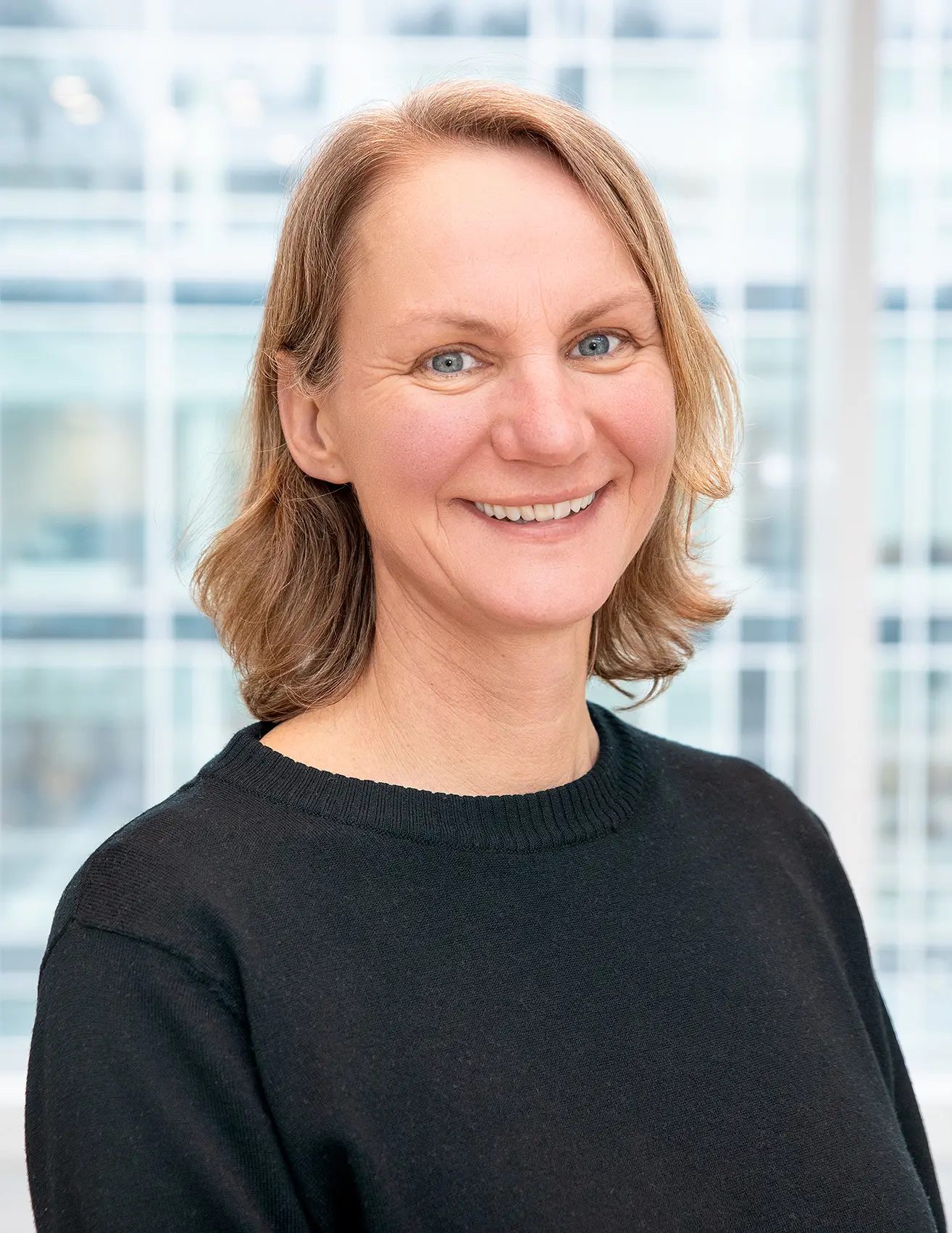 Portrettbilde av Hanne Cathrine Lie som smiler til kameraet.