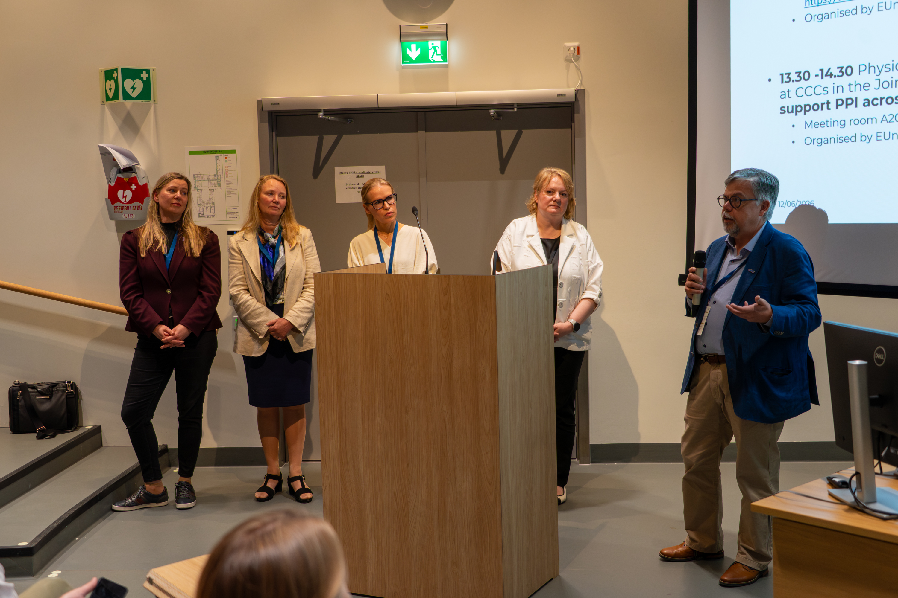 Fra Nordic-Baltic CCC-konferansen i Oslo hvor fire deltakere står på en scene og en femte snakker foran en skjerm.