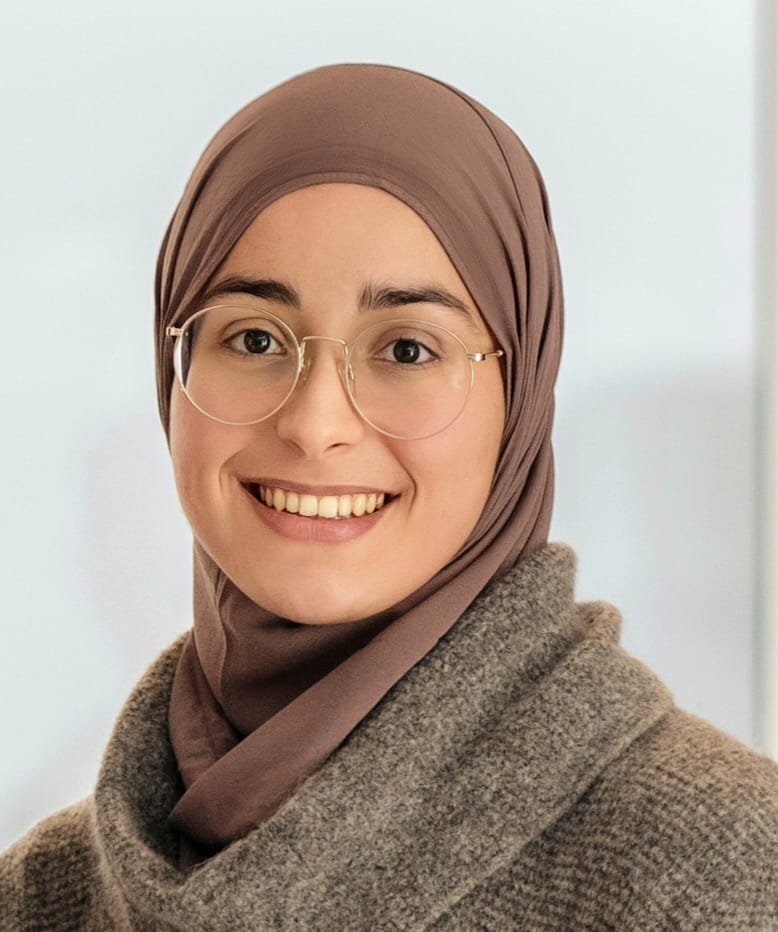 Portrettfoto av Imane Bardan, en smilende ung kvinne med briller og lys brun hijab