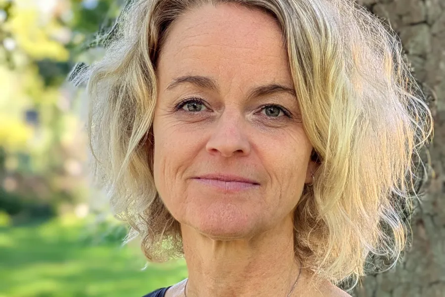 Portrettbilde av Anja Vaskinn, fotografert ute foran et tre og med gress i bakgrunn