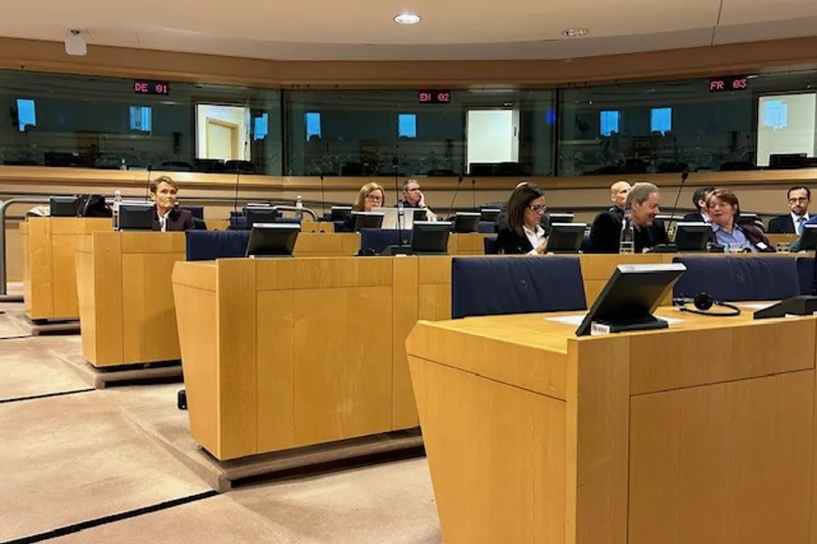 A group of people sitting at a table with laptops