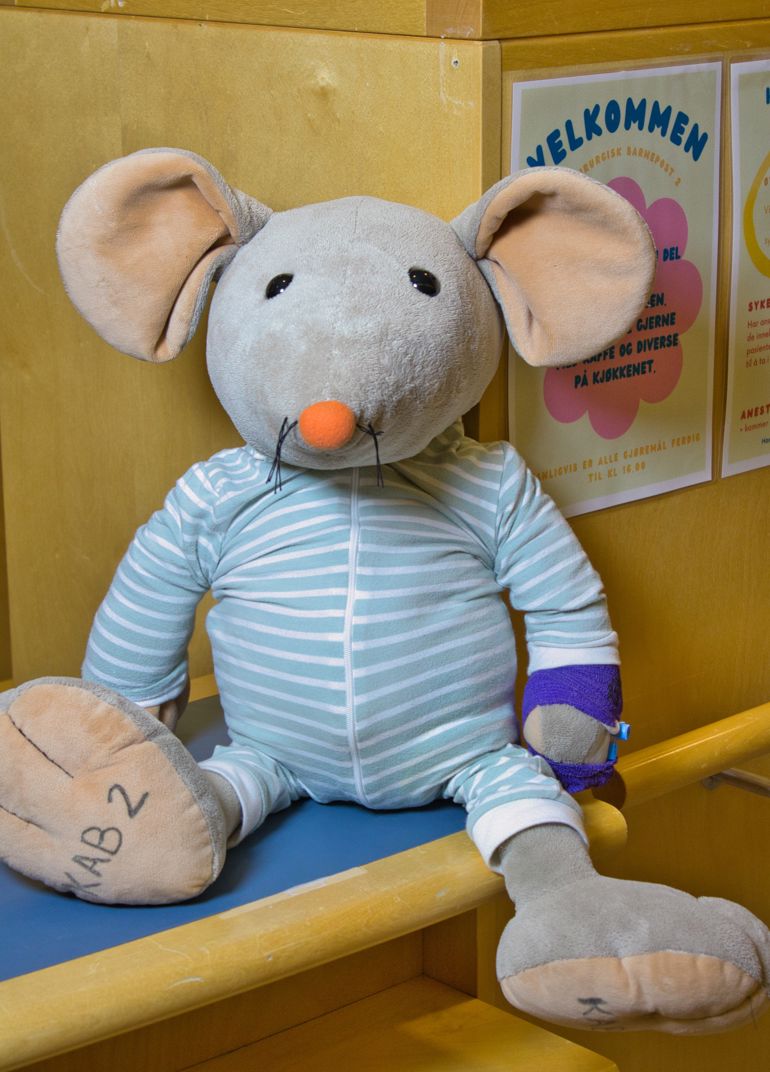 Rasmus bamsen sitter på en benk