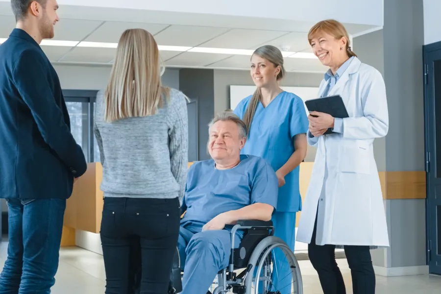 En gruppe mennesker som står rundt en person i rullestol