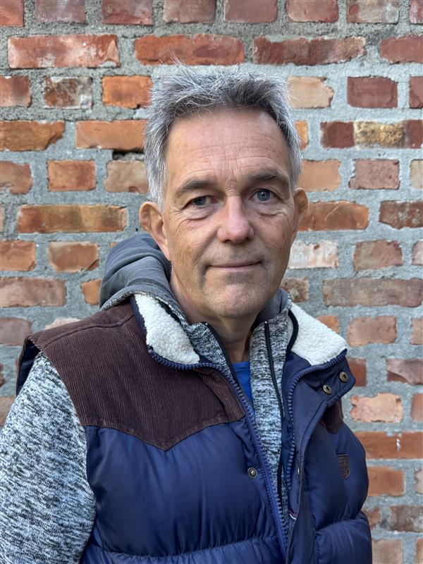 En mann foran en murvegg