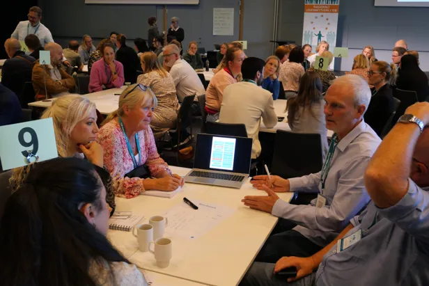 Foto av deltakere på TSB-lederkonferansen som diskuterer i grupper