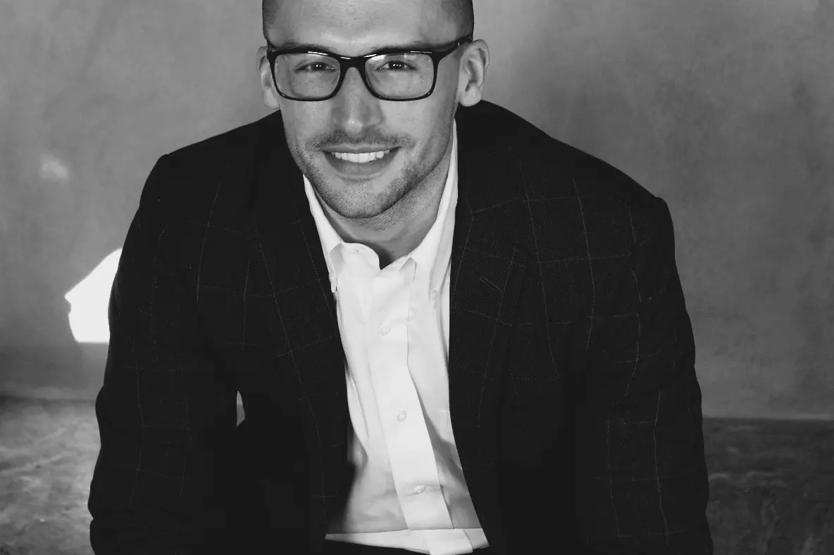 Bildet viser en mann som smiler.