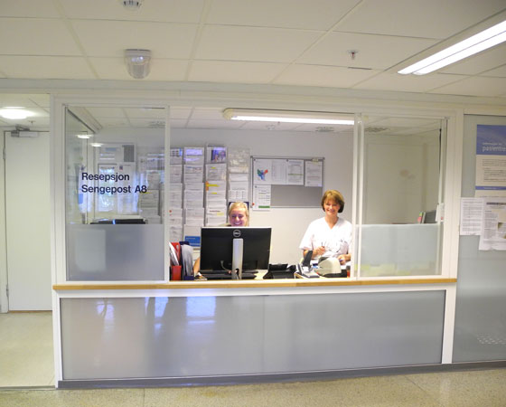 En mann og kvinne som sitter ved et skrivebord med en datamaskin