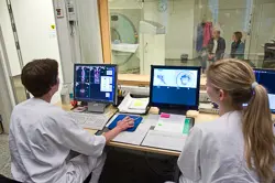 Noen få personer som jobber ved en datamaskin