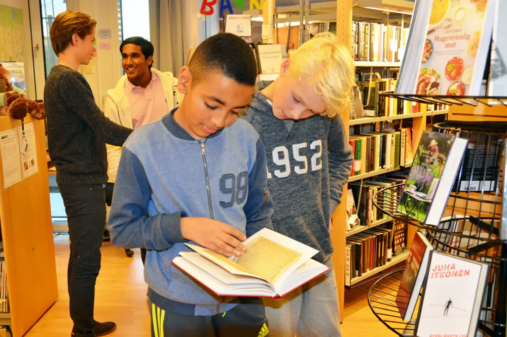 barn som leser bøker på pasientbiblioteket