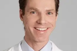 Portrettbilde av Erlend Landsend ikledd legefrakk og slips.