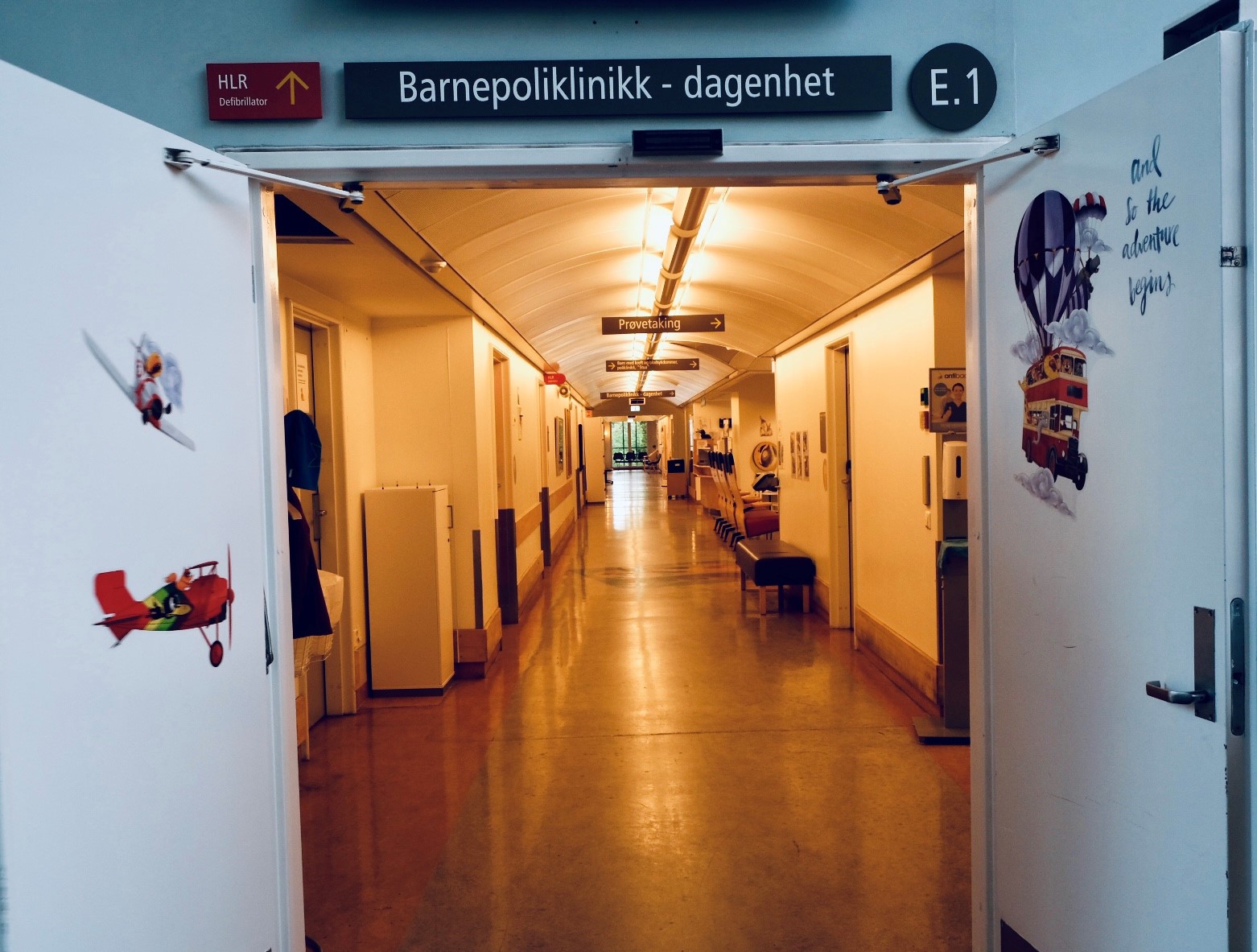 Inngangen til poliklinikken og dagenheten med døren oppe. Man kan se innover i en lang gang.