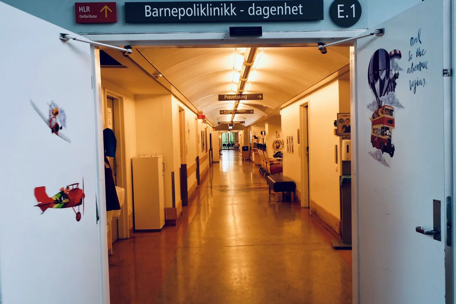 Inngangen til poliklinikken og dagenheten med døren oppe. Man kan se innover i en lang gang.