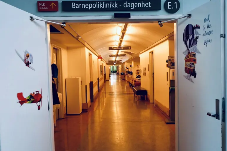 Inngangen til poliklinikken og dagenheten med døren oppe. Man kan se innover i en lang gang.