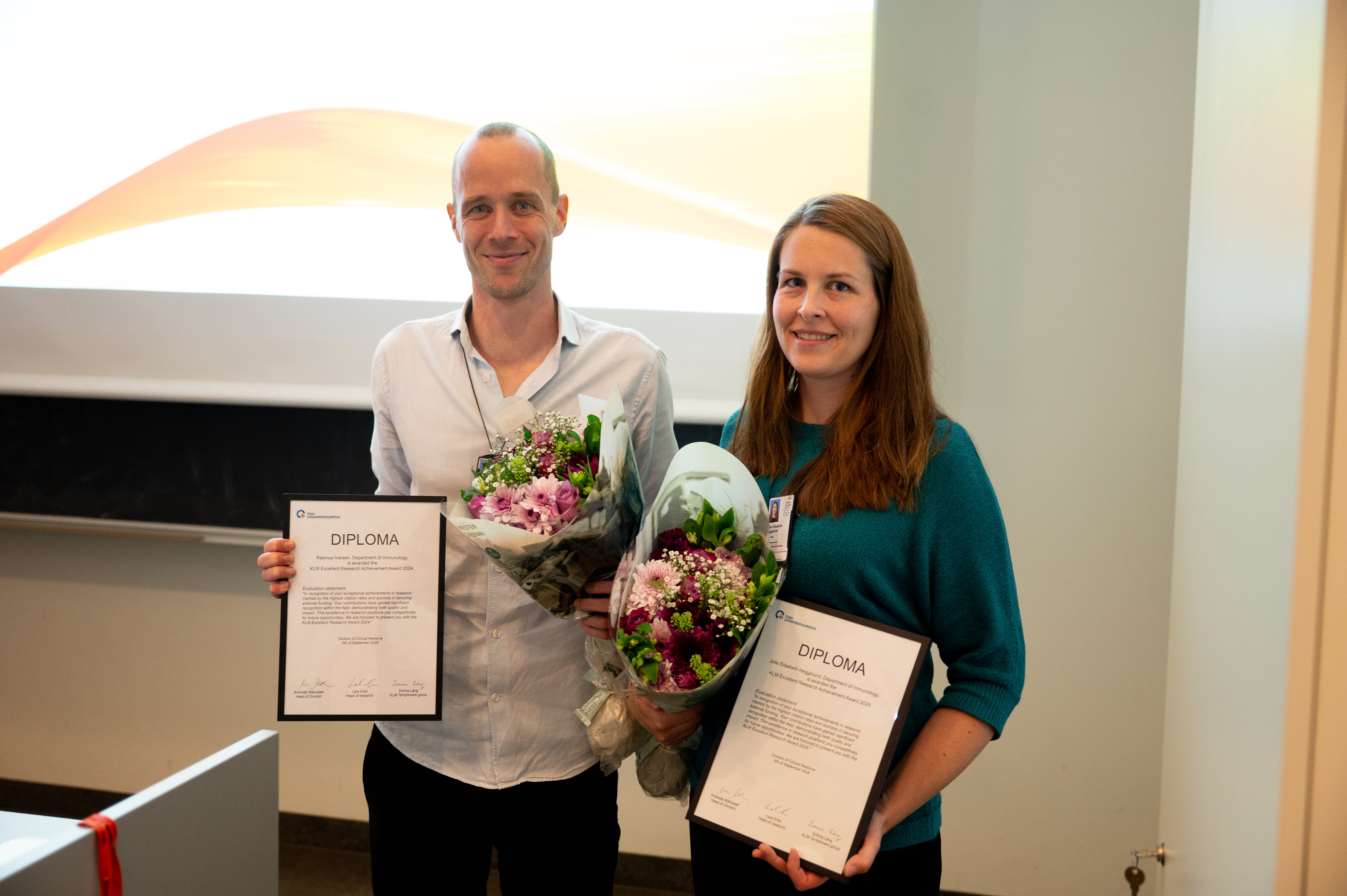 Bilde av en mann og en dame som holder pris og blomster