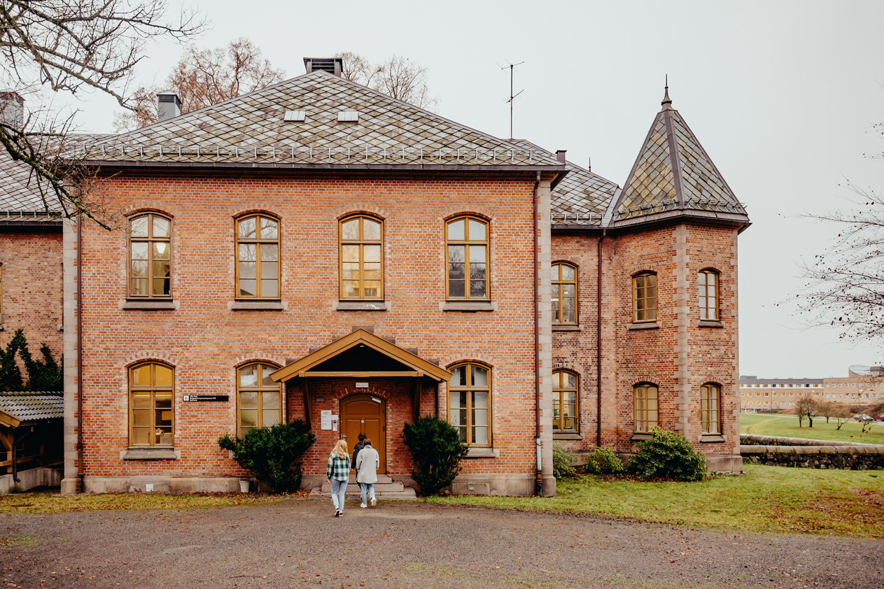 Tre mennesker går mot hoveddøra i Nasjonal kompetansetjeneste TSBs kontorlokale på Gaustad sykehus.