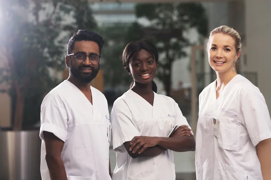 Tre sykepleiere som smiler