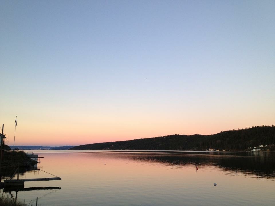 En vannmasse med trær og åser i bakgrunnen