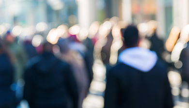 Uskarpt bilde av en by-gågate, folk bakfra ute