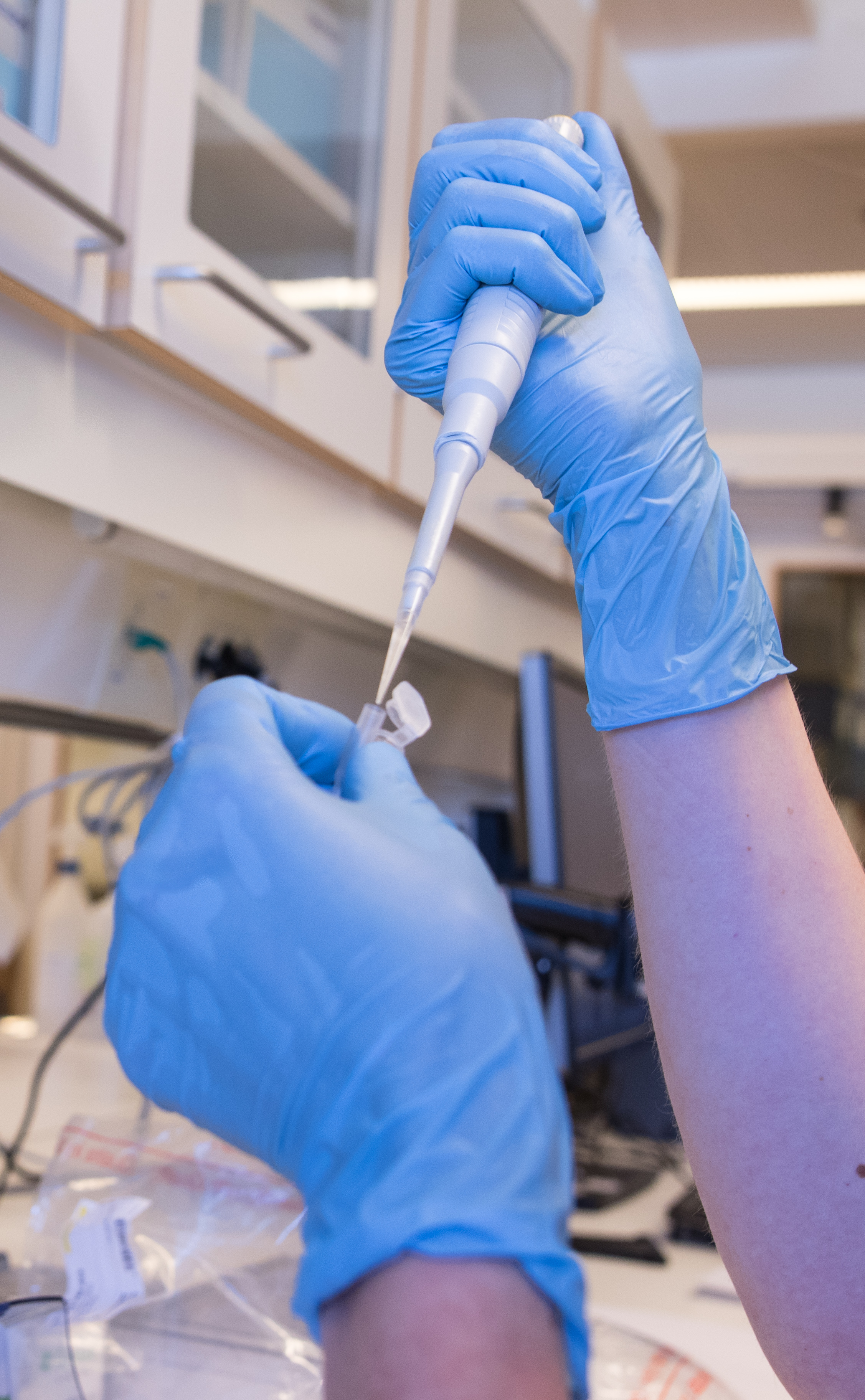 Bilde av to hender som holder en sprøyte og pipette