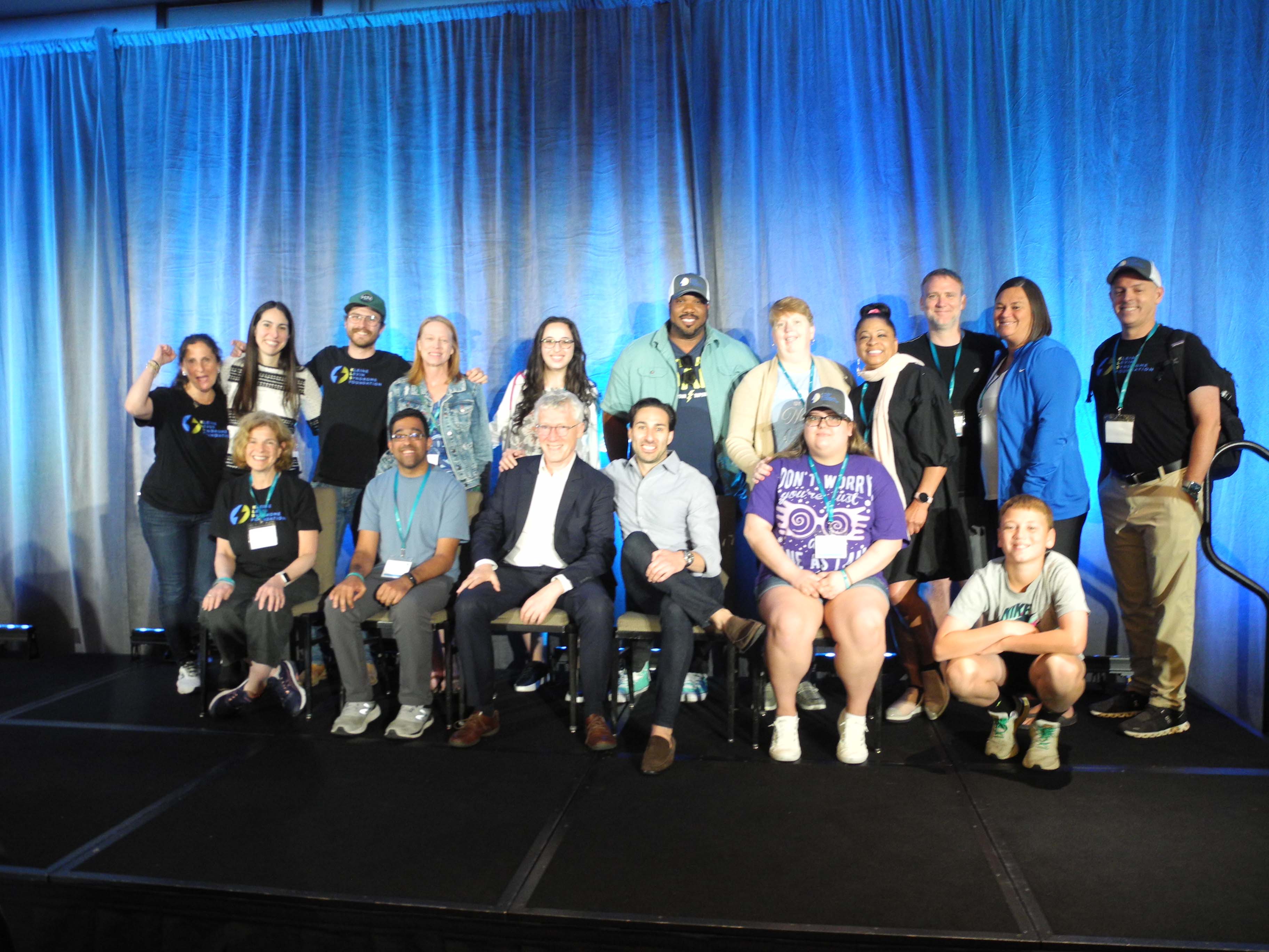 18 av deltakerne på konferansen, oppstilt på scenen.