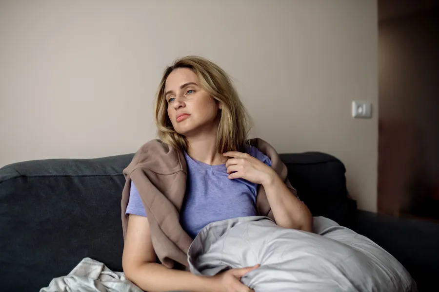 bilde av dame med fatigue sliten i sofaen