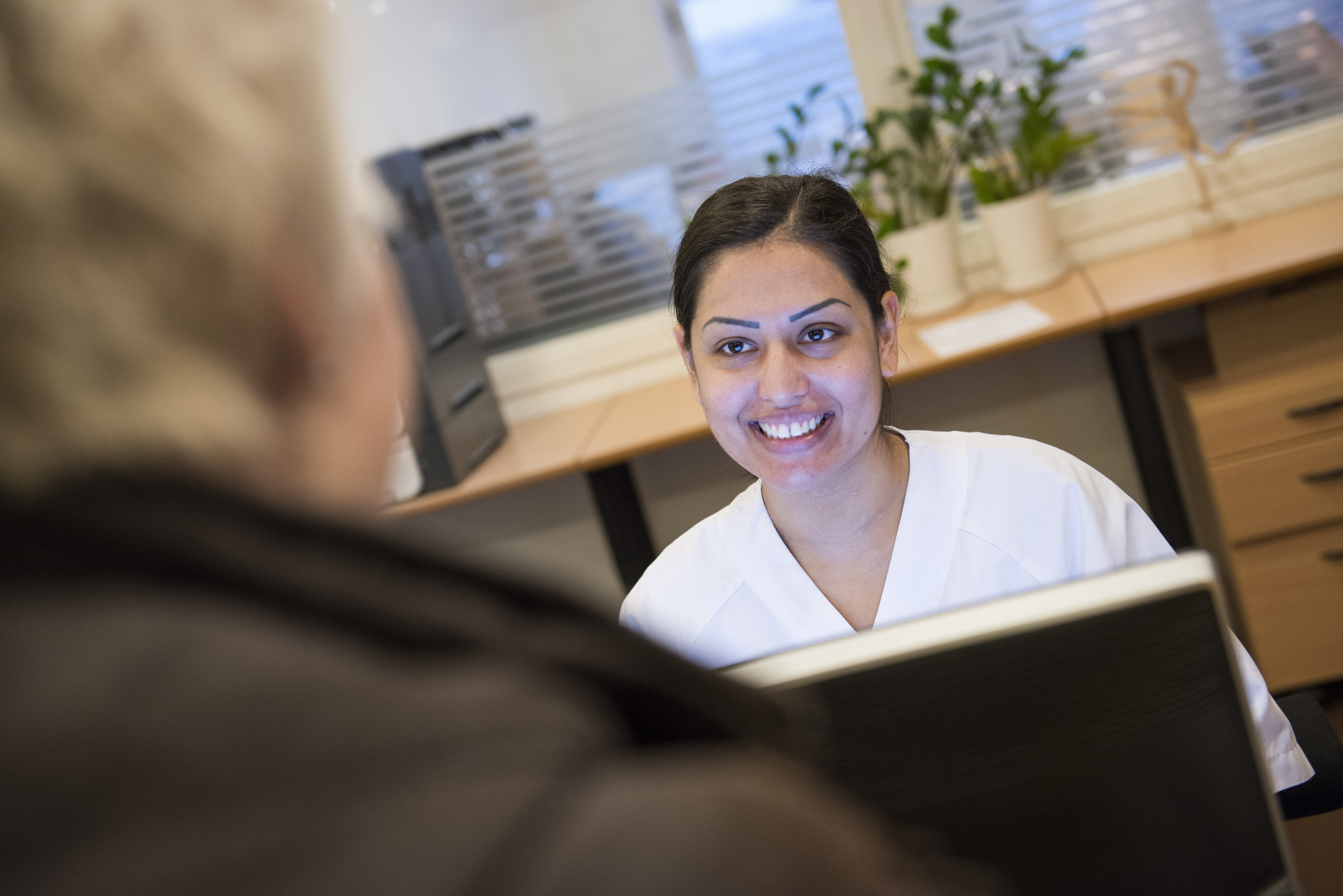 Foto av en mann som snakker med en kvinnelig resepsjonist