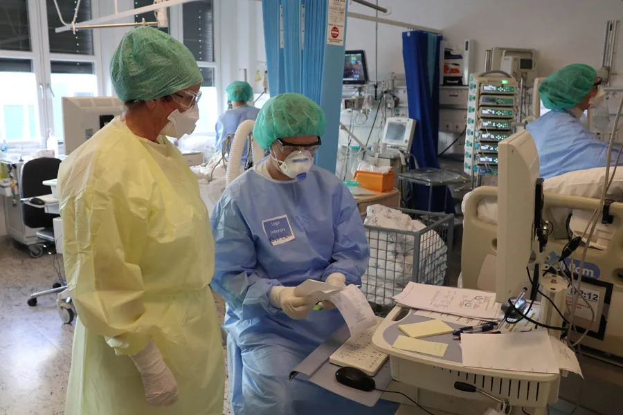 En gruppe mennesker i kirurgiske scrubs som arbeider i et rom