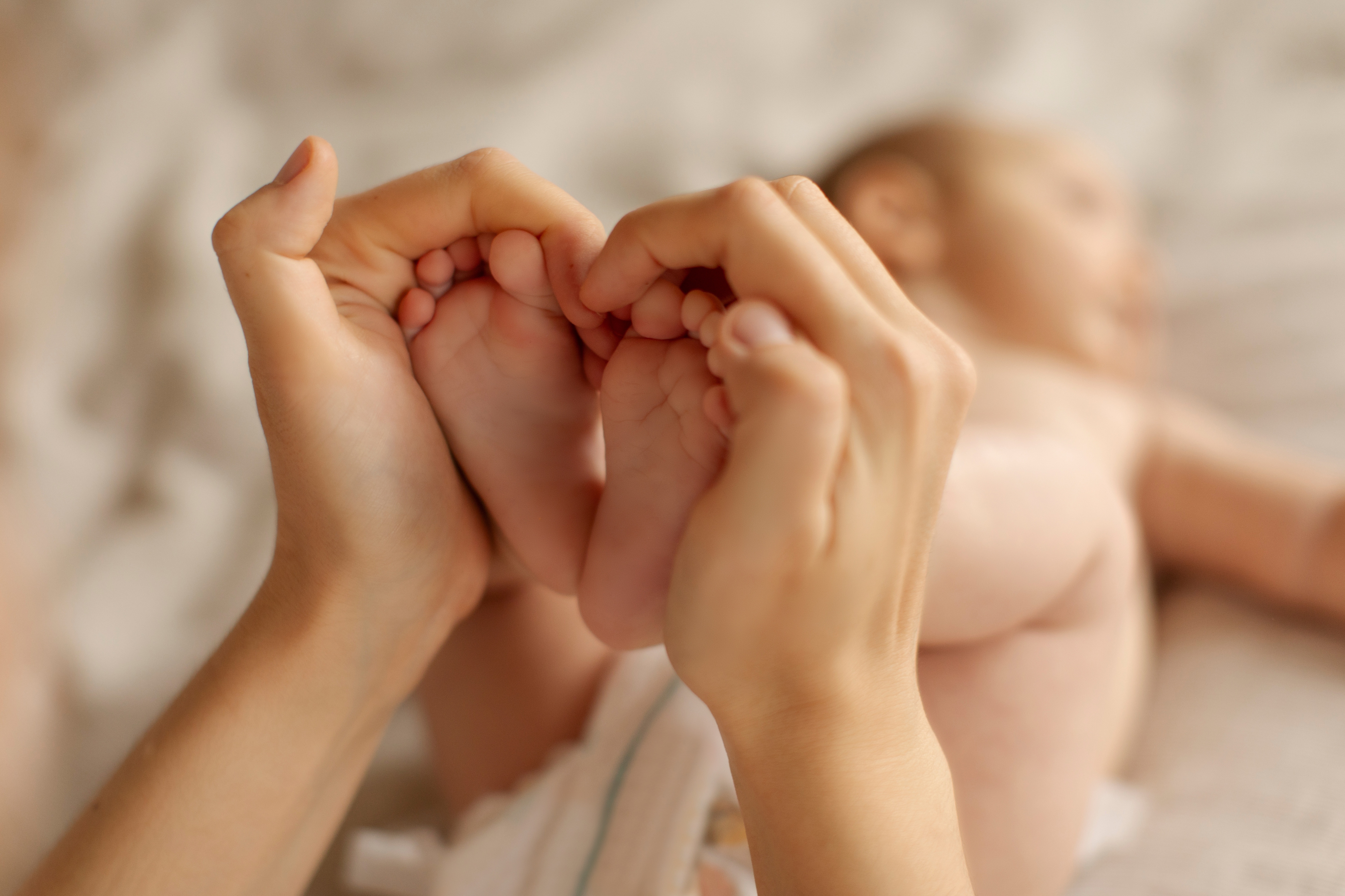 babyføtter i voksne hender