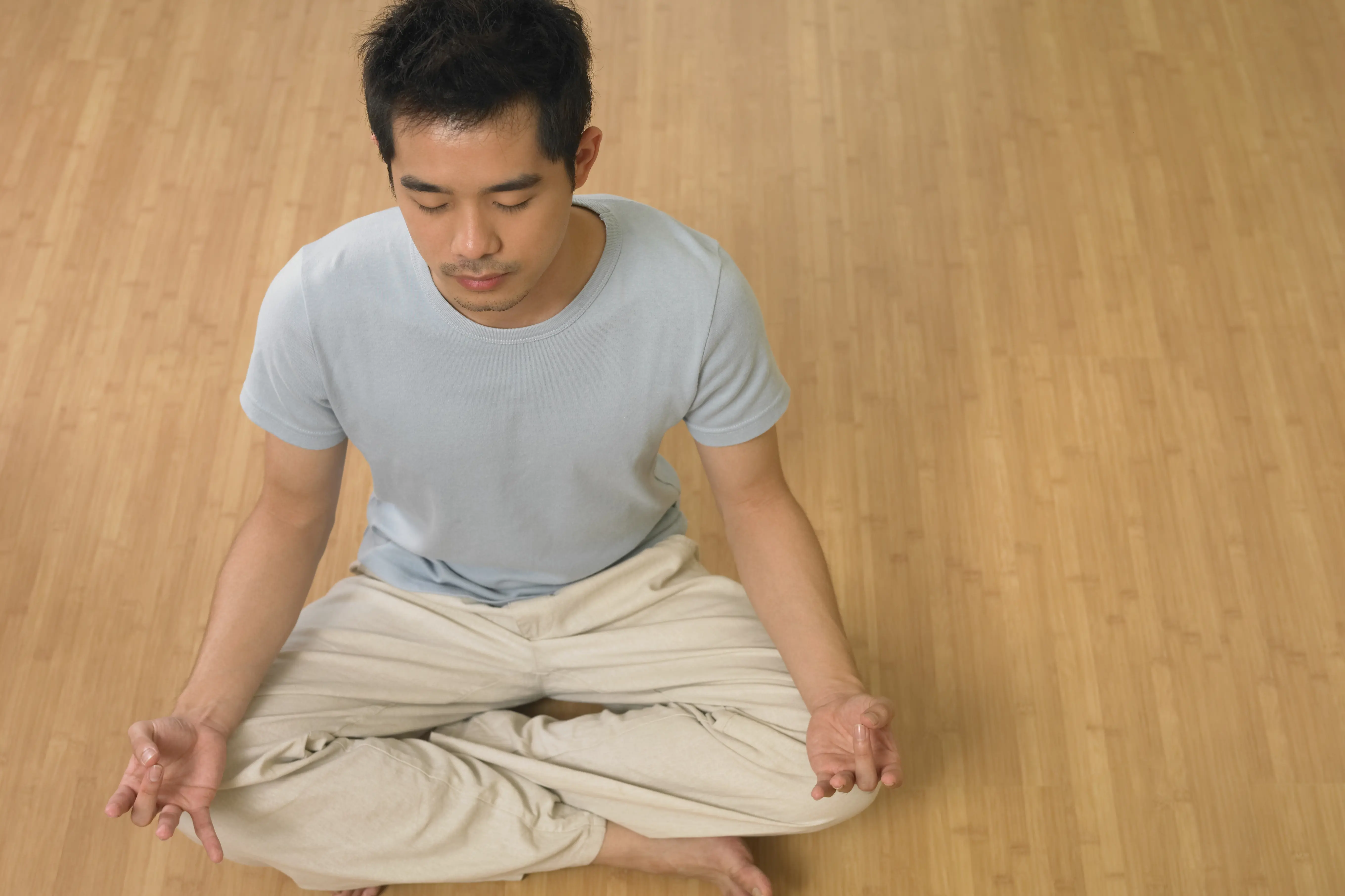 En mann sitter på gulvet og mediterer.