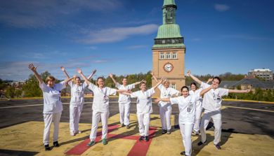 En gruppe mennesker som poserer for et bilde foran et tårn