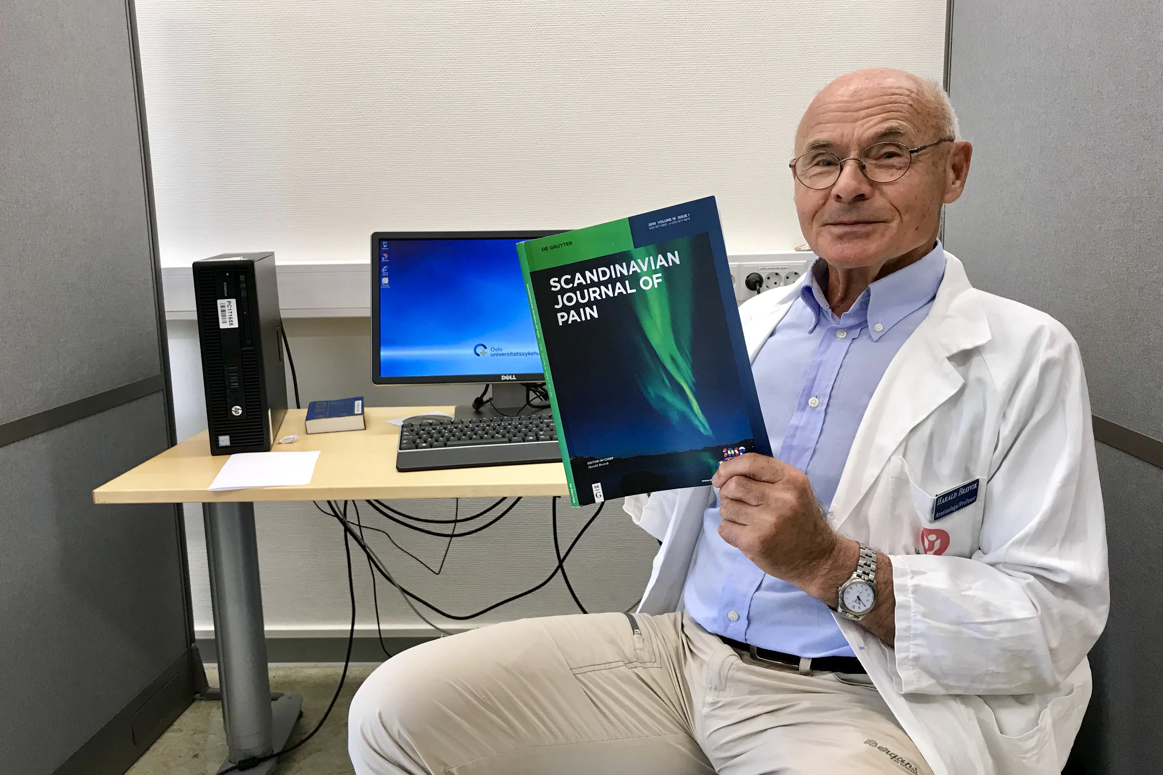 Bildet viser en eldre mann med et magasin i hendene.