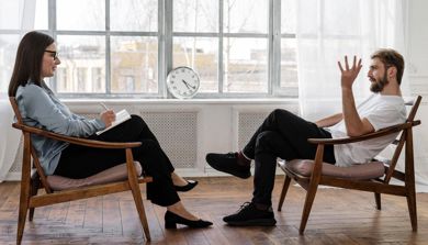 Illustrasjon av en mann som snakker med en person som kan være en psykolog