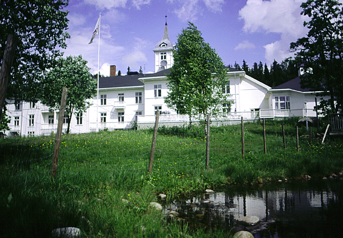 En dam foran et hvitt hus