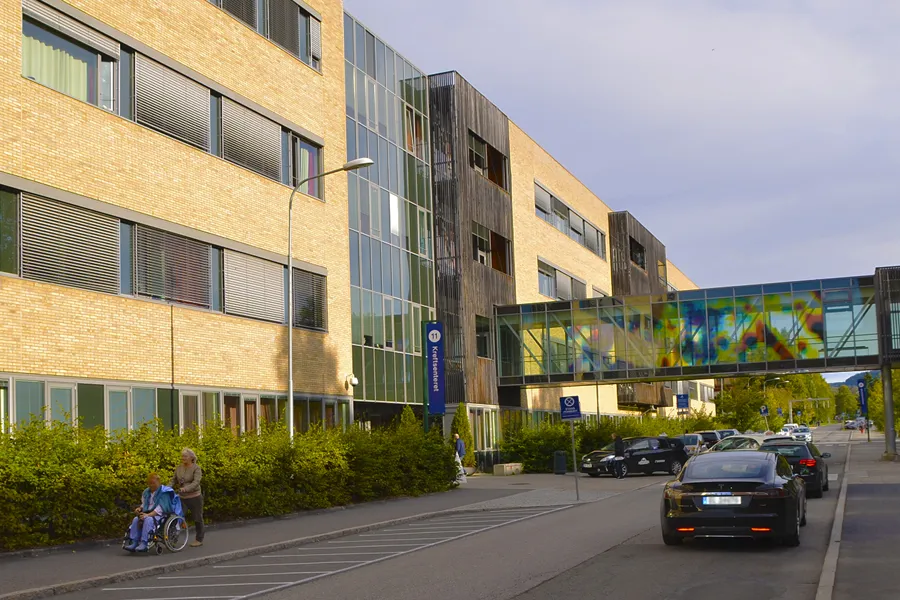 En gate med biler og mennesker på den ved siden av en bygning